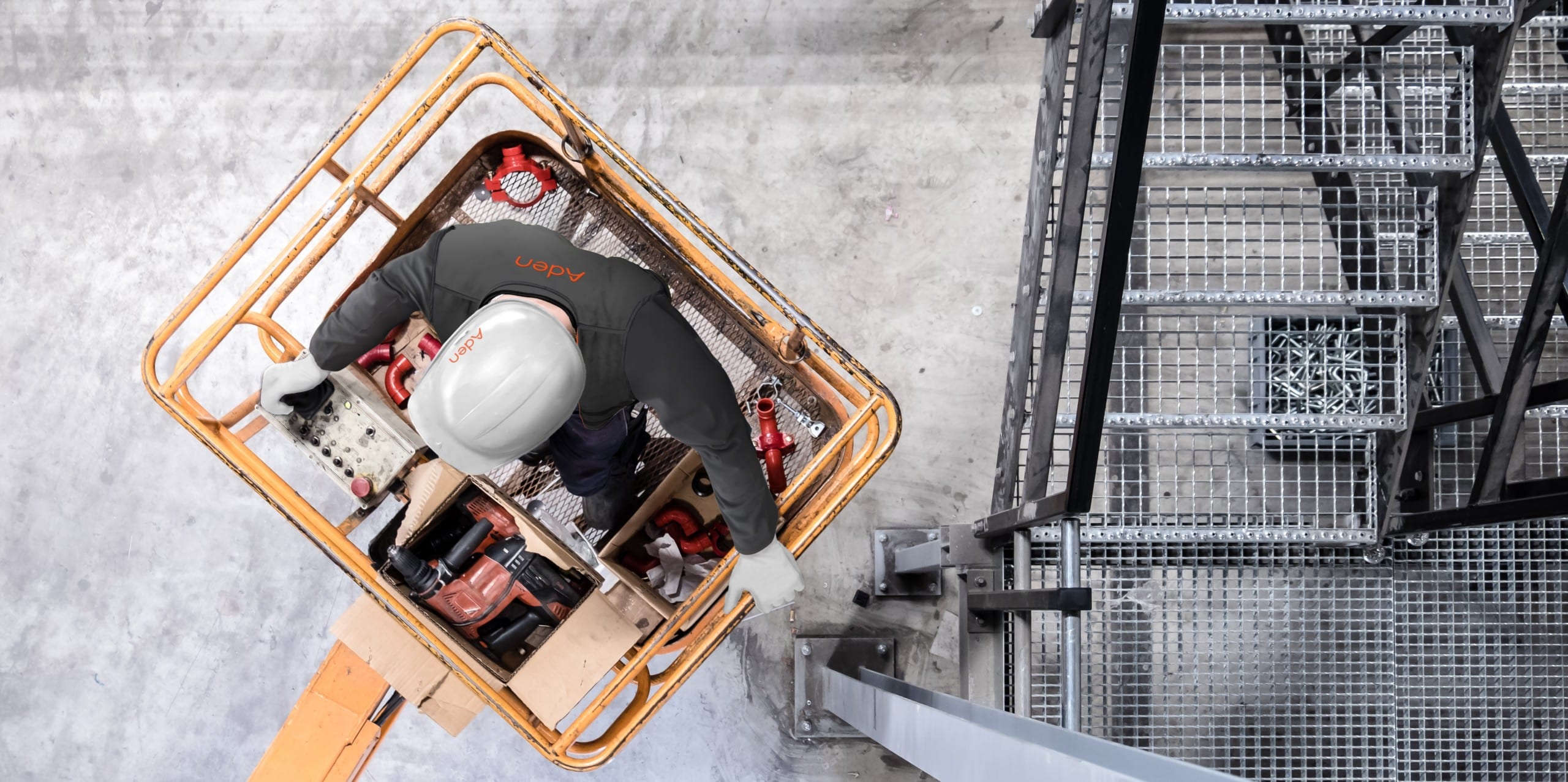 Aerial of a worker with white hardhat on a cherry picker